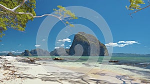 Beautiful scene of El Nido coastline with tropical island in background framed by moving tree branches. Palawan