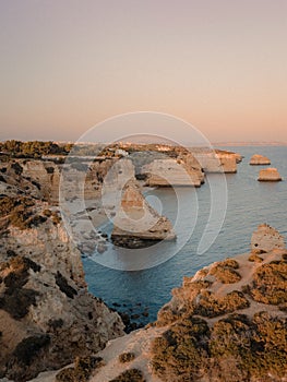 Beautiful scene of Marinha Beach with rocky formation in Portugal at sunset time
