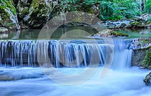 Beautiful scene of mountain waterfall with stone cascade in Serb