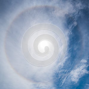 Beautiful scene of the sun halo phenomenon with blue sky and white clouds