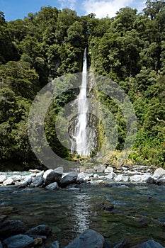 A beautiful scene of Thunder Creek Falls and the Haast River consists of pure, fresh water from a glacier. It is located near the
