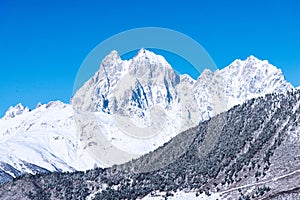 Beautiful sceneric view of Caucasus mountain. The way to mountain with pine forest covered with snow in winter season at Mestia