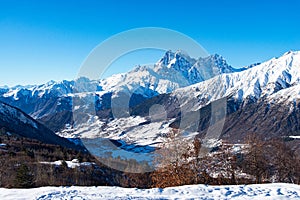 Beautiful sceneric view of Caucasus mountain. The way to mountain with pine forest covered with snow in winter season at Mestia