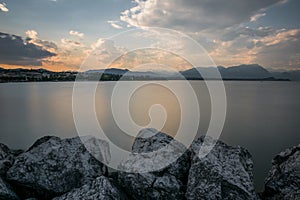 Beautiful scenery of huge rocks near the lake Garda with the reflection of the sunset sky in Italy