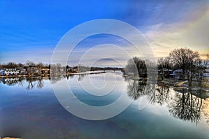 Beautiful scenery of a lake reflecting the trees and a cloudy colorful sky in the background