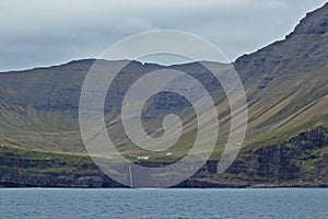 Beautiful scenery of Mulafossur Waterfall Goose valley and Gasadalur village view from water. Vagar island Faroe is