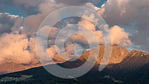 Beautiful scenery of rocky mountainous landscape at susnet enveloped in huge puffy clouds