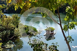 A beautiful scenery of small house in a lake in Golden park (Zlaten park) in Lukovit, Bulgaria. Duck swim in