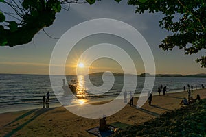 Beautiful scenery sunset with glowing orange light painted on cloudy sky become to twilight dawn, above the sea, long tail boat