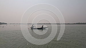 Beautiful scenery of a wooden boat floating on the river. A sailor sailing a boat on the river. Beautiful rural life and scenic