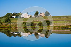 Beautiful scenic barn reflects in mirror like pond