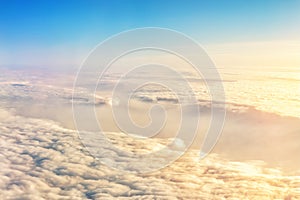 Beautiful scenic dramatic morning sunrise cloudscape aerial view from plane window. Gradient colored fluffy clouds during aircraft