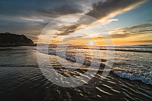 Beautiful scenic panoramic view of a colorful sunset on the beach at the Atlantic Ocean, in north of Spain, Europe