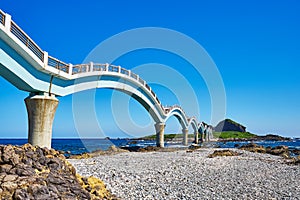 Beautiful scenic of Sanxiantai arch bridge with blue ocean with Three saint island in behind at Chenggong district photo