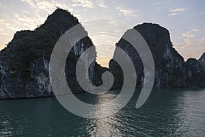 Beautiful scenic view of two large rock formations at sunrise, Halong Bay, Vietnam