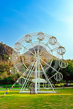 Beautiful scenic with white ferris wheel decorated with lights and small flags for fun and enjoyment of festival or carnival stand