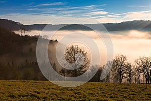 Beautiful scenic winter landscape with a fog filled valley