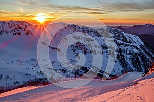 Beautiful scenic winter mountain sunset landscape of snowy Caucasus Mountains and ski slope of Gorki Gorod mountain ski resort in