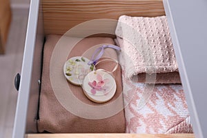 Beautiful scented wax sachets and clothes in dresser drawer, closeup