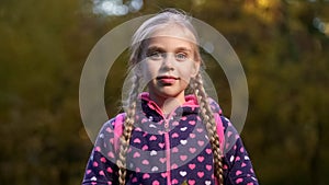 Beautiful school aged girl with two pigtails smiling and looking at camera