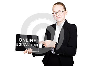 Beautiful school girl in a business suit holds a pc tablet in his hands and looking into the camera, on a pc tablet