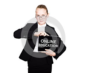 Beautiful school girl in a business suit holds a pc tablet in his hands and looking into the camera, on a pc tablet