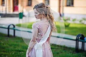 Beautiful schoolgirl in dress at the prom at school.