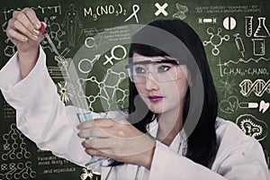 Beautiful scientist analysing liquid at workplace