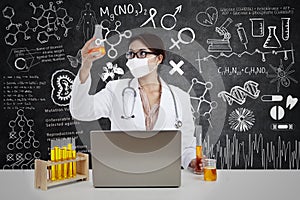 Beautiful scientist with flask and laptop in lab