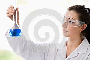 Beautiful scientist looking at a flask