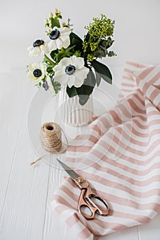 Beautiful scissors, bouquet of anemones, striped fabric