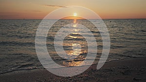 Beautiful sea shore on sunrise. Dramatic burning sky with reflection on water surface, summer beach panorama with calm