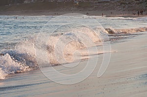 Beautiful sea wave on sandy beach at summer sunset