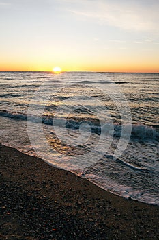 Beautiful sea waves foam closeup and red sky with sun in sunrise light on tropical island. Waves in ocean at sunset. Tranquil calm