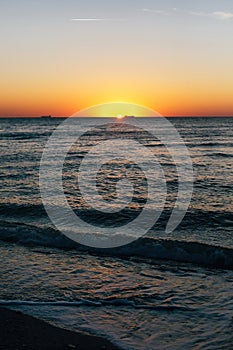 Beautiful sea waves foam closeup and red sky with sun in sunrise light on tropical island. Waves in ocean at sunset. Tranquil calm