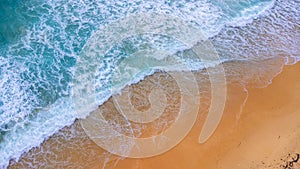 Beautiful sea waves and white sand beach in the tropical island. Soft waves of blue ocean on sandy beach background from top view