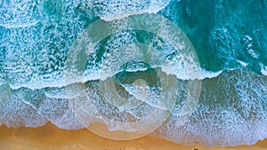 Beautiful sea waves and white sand beach in the tropical island. Soft waves of blue ocean on sandy beach background from top view