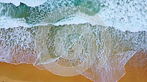 Beautiful sea waves and white sand beach in the tropical island. Soft waves of blue ocean on sandy beach background from top view