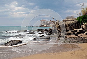 Beautiful seascape with alone house on stone beach above sea waves