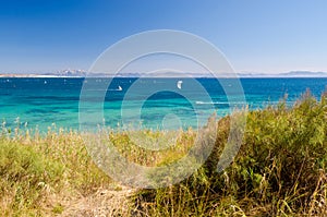 Beautiful seascape with blue sky and Atlantic ocean. A lot of kiteboarders trainig. Morocco and mount Jebel Musa on the background