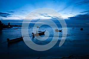 A beautiful seascape with boats and fishermen after sunset. deep blue tones