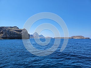 Beautiful seascape in daylight with huge rocks on the shore under blue sky