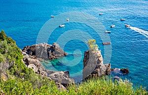 Beautiful seascape at La Grotta Bay, Corfu, sunny summer day - small boats on calm sea in distance