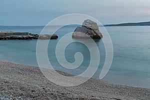 Beautiful seascape, rock in Adriatic sea near Baska Voda in Croatia at summer dusk. Ikovac beach