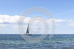 Beautiful seascape. Sailboat floats on the blue sea.