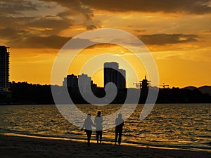 Beautiful seascape scenery with three girls during sunset at Tanjung Lipat beach,Sabah.