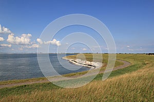 Beautiful seascape of scheldt river with a green sea dike along the water