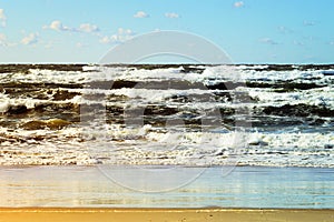 Beautiful seascape with sea waves, blue sky, white cumulus clouds and sand beach. Summer vacation tropical landscape.