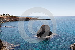 Beautiful seascape. Travel concept. Seascape on the background of the wild rocky coast. Wild beach, azure water and rocks