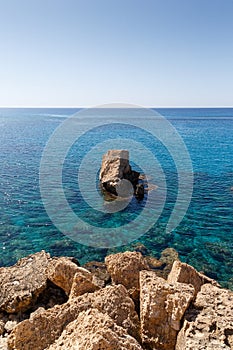 Beautiful seascape. Travel concept. Seascape on the background of the wild rocky coast. Wild beach, azure water and rocks